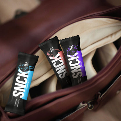 Four SNICK protein bars in a suitcase