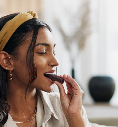 Woman eating a SNCK bar with a blurred background