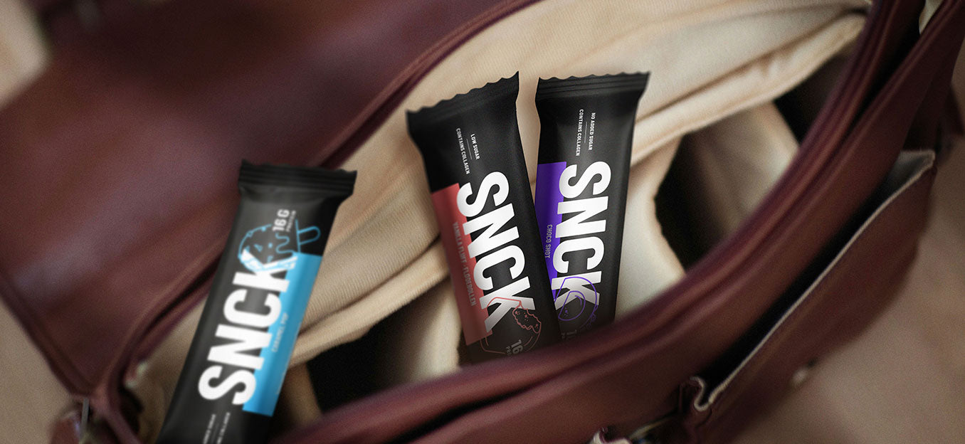 Three SNICK bars in front of a brown leather bag